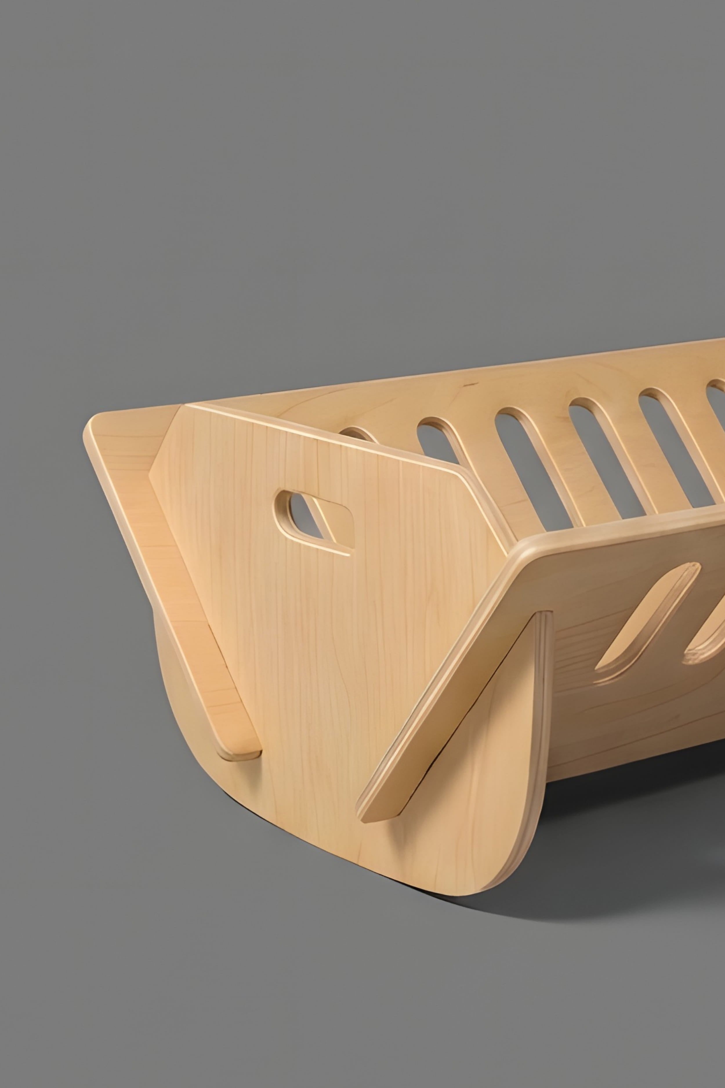 wooden cot from side on grey background
